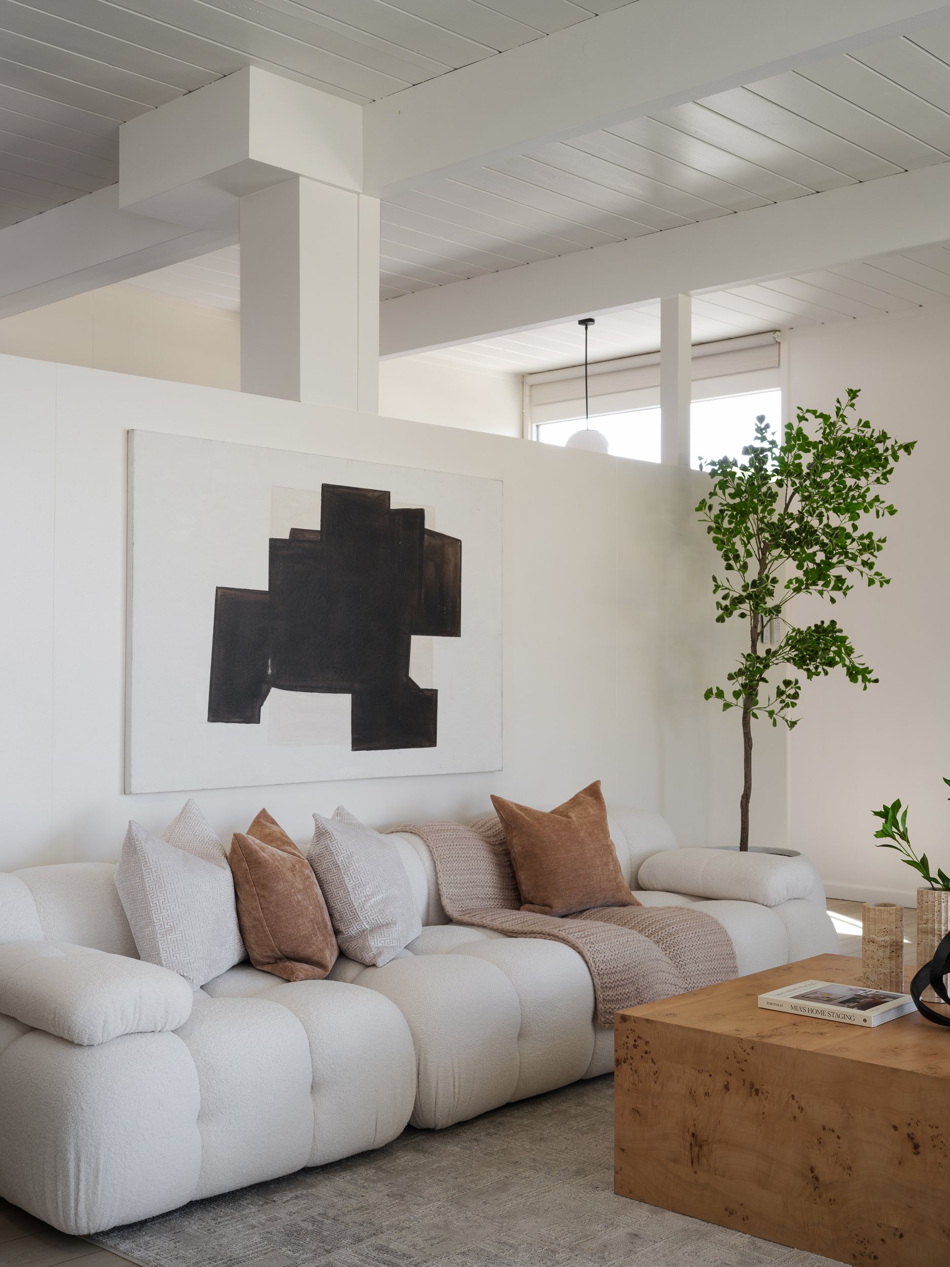 Cream sofa, linen pillows, and quiet abstract art showing restrained San Mateo staging