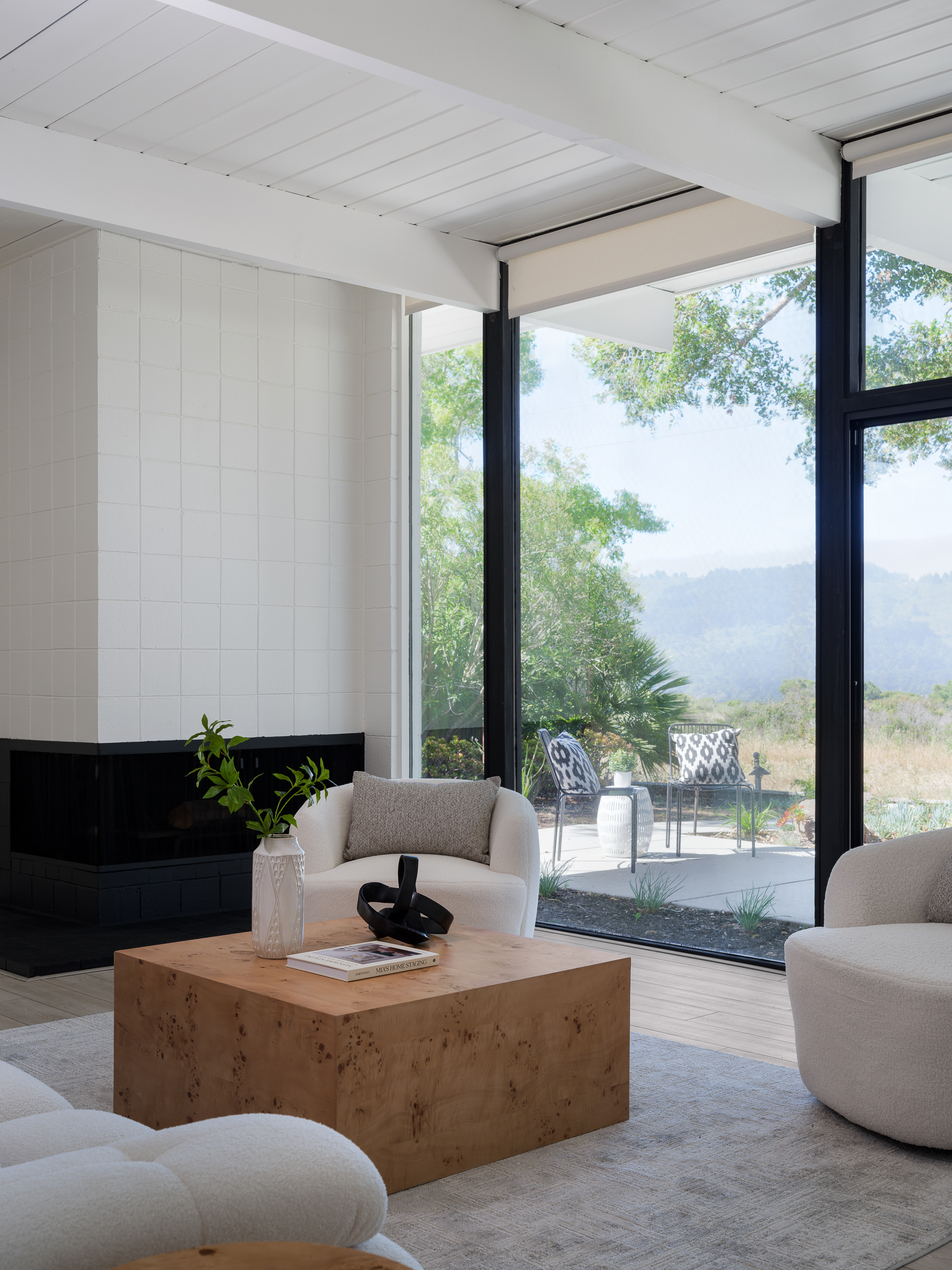 Neutral living room seating arranged around a rug and wood table to define clear edges
