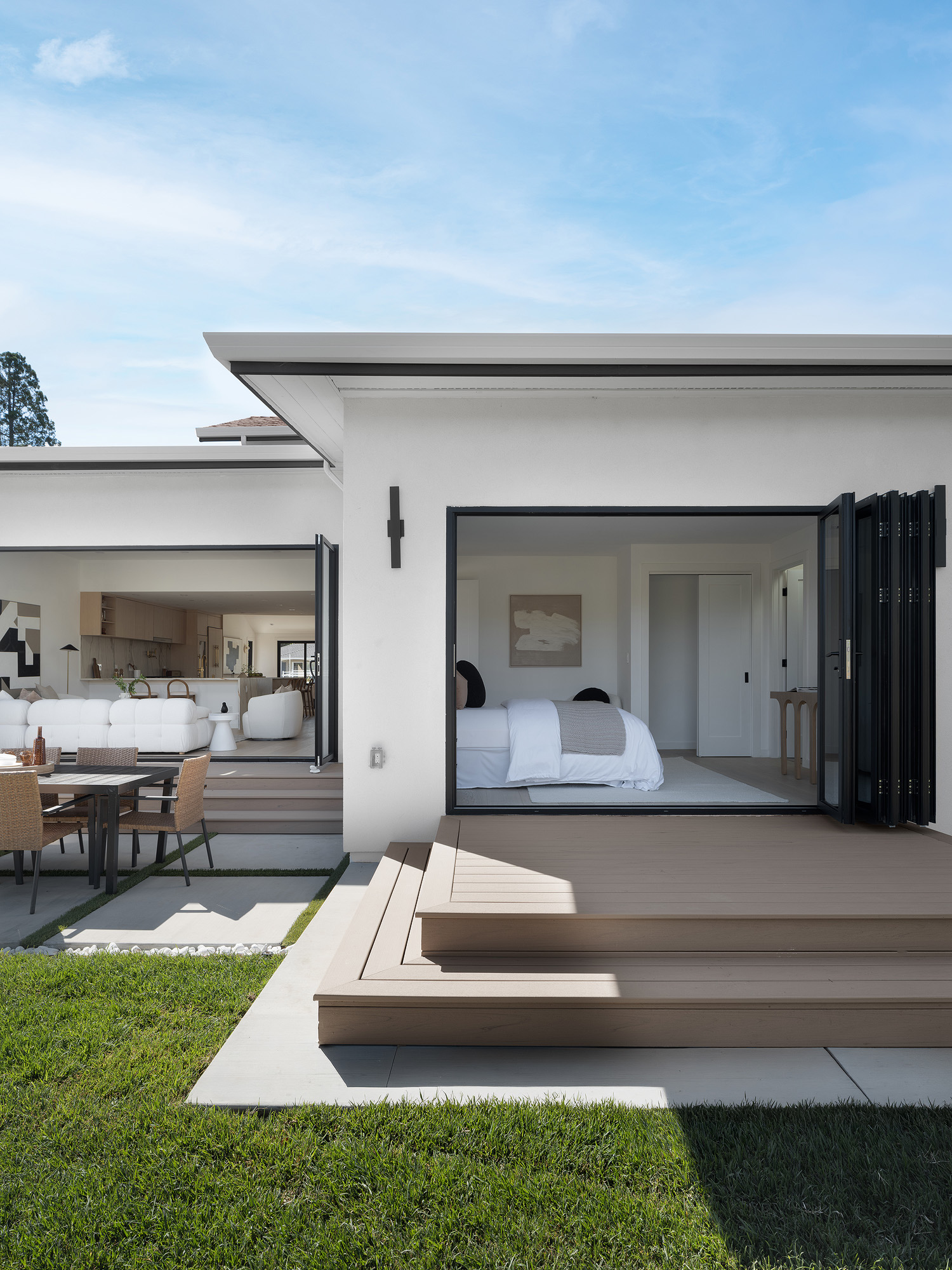 Backyard deck with folding glass doors, lawn, and patio dining set matching open house photo expectations