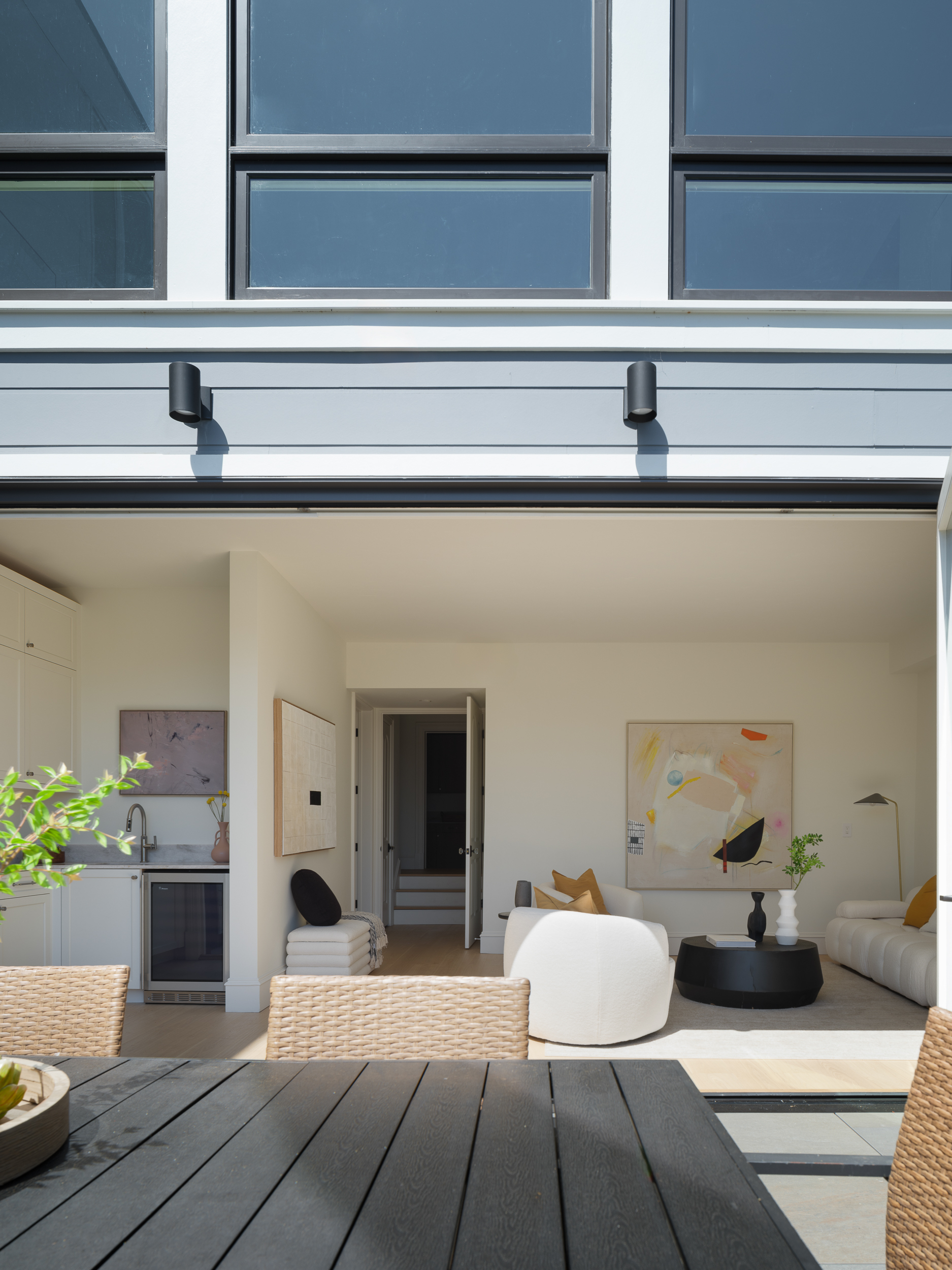 Open living area with cream upholstery and patio dining, showing staged zones for walkthroughs