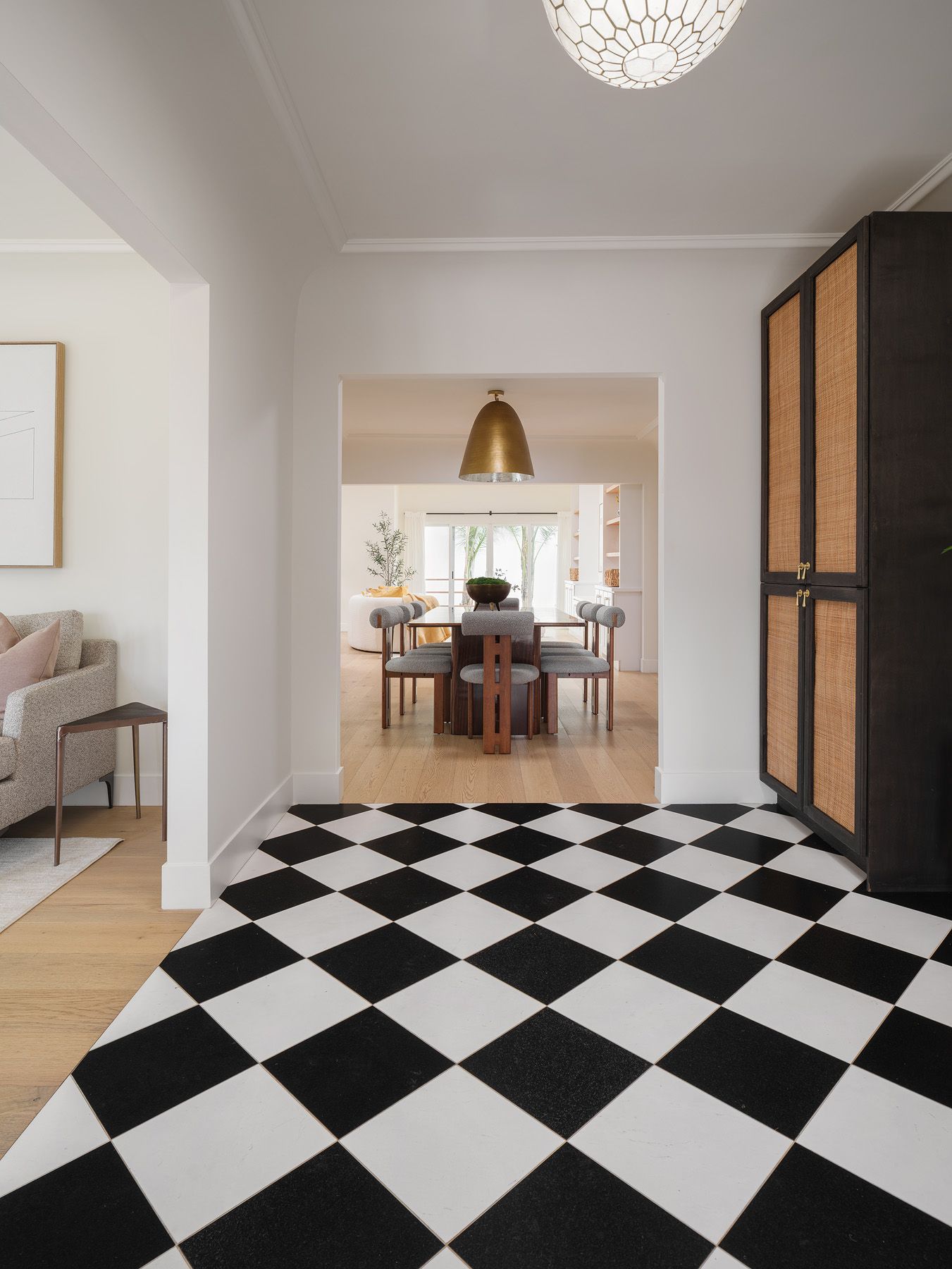 Checkerboard foyer opening to a warm dining room shows the clear focal point visible from the doorway