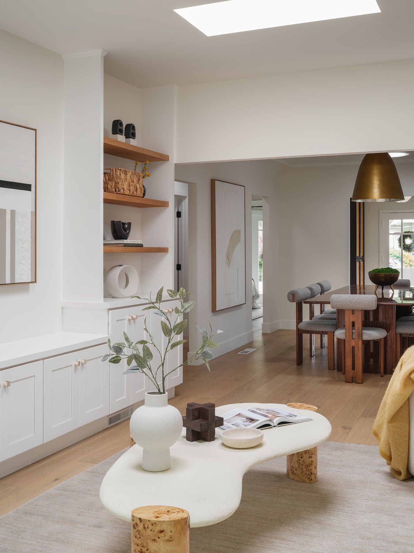 Open living and dining sightline with an edited coffee-table vignette staged for clear real-estate photography