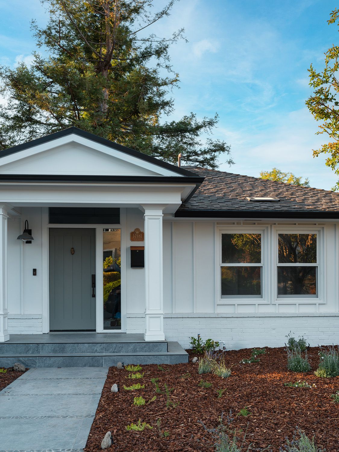 Modern farmhouse entry with blue-gray door and polished curb appeal for a prepared June sale